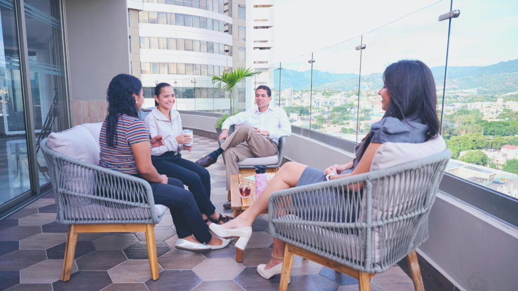 Business team having a casual meeting on a rooftop terrace with a cityscape view.